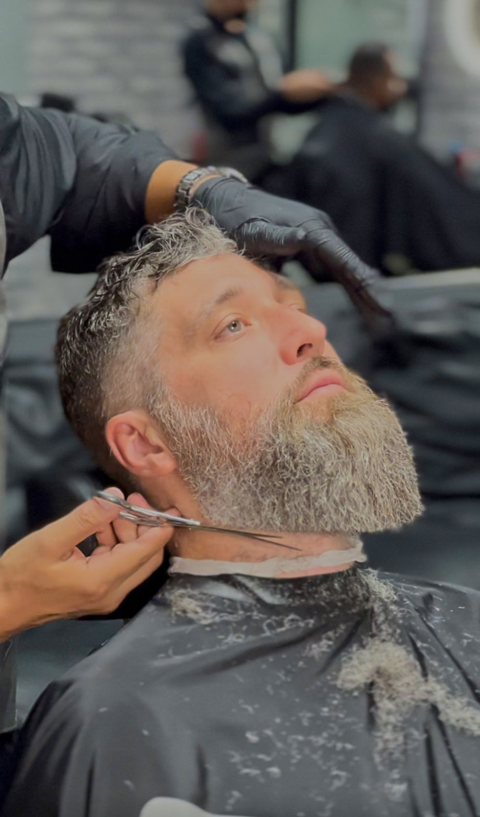 Barbero perfilando una barba con tijera en Mister Cut